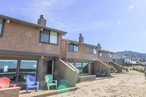 Wooden houses with porches extending into the sand on the beach